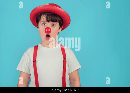 Funny bambino con clown naso su sfondo blu Foto Stock