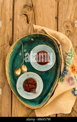 Vista superiore colpo di confettura di mele cotogne in piccolo blu di piastre in ceramica su legno rustico del piano portapaziente. Foto Stock