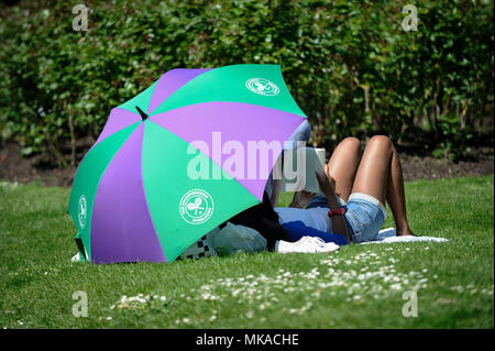 Londra, Regno Unito. 7 maggio 2018. Regno Unito - Previsioni del tempo - una donna ripari sotto un grande ombrello di Wimbledon il più caldo il May Bank Holiday sul record nel Regent's Park. Credito: Stephen Chung / Alamy Live News Foto Stock