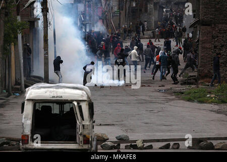 Il Kashmir. Il 7 maggio, 2018. Manifestanti del Kashmir eseguire dopo la polizia indiana fire le scatole metalliche del gas lacrimogeno per disperdere i manifestanti in Srinagar la capitale estiva di Indiano Kashmir controllato su maggio 07, 2018. La polizia ha sparato gas lacrimogeni canestri, pellet e granate stun per disperdere la folla arrabbiata.massiccia anti-India scontri scatenarsi in Srinagar seguendo le uccisioni di dieci persone tra cui cinque ribelli e cinque i civili dalle forze di sicurezza indiane nel sud del Kashmir. Credito: Faisal Khan/ZUMA filo/Alamy Live News Foto Stock