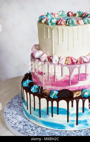 Tre livelli torta colorata con macchie colorate di cioccolato su uno sfondo luminoso. Immagine di un menu o di un catalogo di prodotti dolciari con spazio di copia Foto Stock