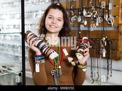 Femmina offre di acquistare collana e bracciali nel negozio di Gioielleria Foto Stock