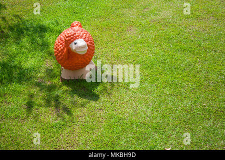 Vista superiore della colorata statua di pecora o di scultura permanente sulla verde erba prato campo del giardino esterno. Foto Stock