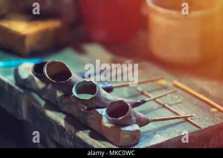 Un decoratore di ceramica ceramica strumenti di pittura piena di vernice. Strumenti vintage, look vintage Foto Stock