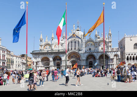 Basilica di San Marco (St Marks Cattedrale in Piazza San Marco, (Piazza San Marco) con le bandiere di Venezia, UE e Italia battenti sul giorno della liberazione, Venezia Foto Stock