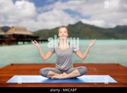 Donna fare lo yoga e la meditazione lotus pongono Foto Stock