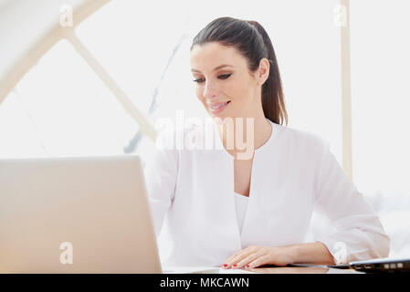 Bella giovane donna utilizzando computer portatile mentre si lavora online. Home office. Foto Stock