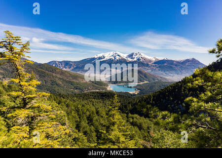 Vista panoramica della Doxa lago e la coperta di neve La Ziria montagna nel Peloponneso Grecia Foto Stock