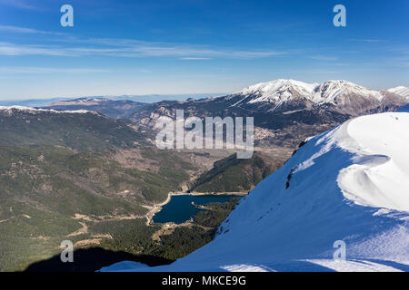 Vista panoramica della Doxa lago e la coperta di neve La Ziria montagna nel Peloponneso Grecia Foto Stock