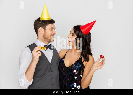 Coppia felice con party soffianti divertendosi Foto Stock