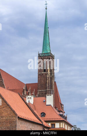 Alta torre e la guglia della chiesa in mattoni in stile gotico. Tetto , piastrella, decorazione in laterizio.La chiesa di Santa Croce di Wroclaw Polonia . Foto Stock