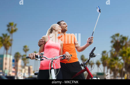 Giovane con la bicicletta e lo smartphone selfie stick Foto Stock