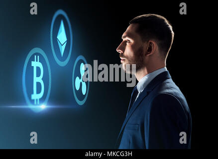 Buisnessman guardando cryptocurrency icone Foto Stock