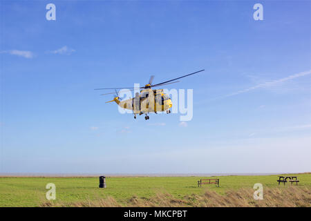 Un Westland Sea King RAF Salvataggio in elicottero sulle manovre sulle scogliere a Walton sul Naze Essex. Foto Stock