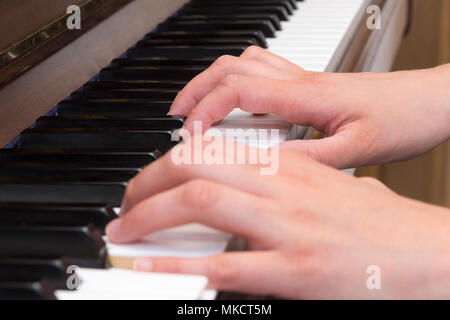 Close up della donna e delle sue mani suonando piano Foto Stock