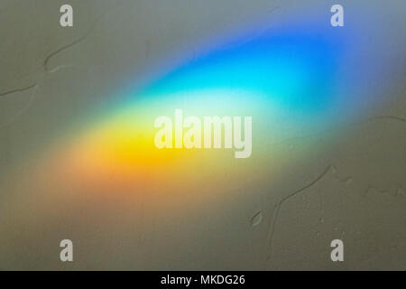 La luce del sole attraverso il vetro macchiato crea abstract effetto prisma sulla parete Foto Stock