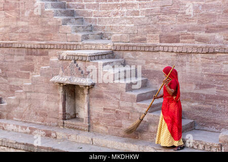 Donna in sari la pulizia dei passaggi a Toorji Ka Jhalara, la fase ben, Jodhpur, Rajasthan, India Foto Stock