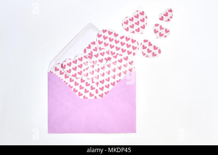 Sfondo con un sacco di cuori di carta. Busta rosa con rosa a forma di cuore le figure tagliato da un nastro di carta su sfondo bianco. Foto Stock