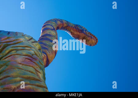 Vista del dinosauro colorato, da sotto contro un cielo blu Foto Stock