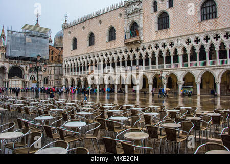 Svuotare i tavoli e le sedie in un caffè sulla Piazza San Marco, con la Basilica di San Marco e il Palazzo Ducale in background, Venezia Foto Stock