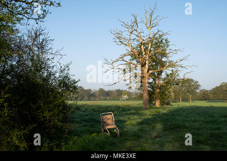 Un ospedale style sedia a rotelle è rimasto abbandonato per lettiera la campagna inglese e su un pubblico Bridleway via in Worcestershire. Foto Stock