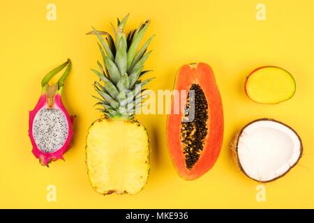 Frutta tropicale laici piatta con taglio ananas, dragon frutta, papaia, mango, cocco e su sfondo bianco Foto Stock