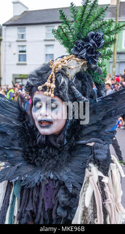 Vestiti in maniera colorata street performer parte di un festival di musica jazz processione vestita come una strega Dancing in the Street di Ballydehob, Irlanda Foto Stock