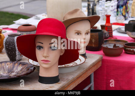 Scena da mercato delle pulci jumble vendita dove la gente vende e compra i giocattoli usati dei cappelli, vestiti, immagini, utensili da cucina e altre cose d'epoca Foto Stock