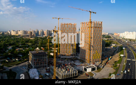 Vista aerea del paesaggio nella città con sotto la costruzione degli edifici e le gru industriali. Foto Stock