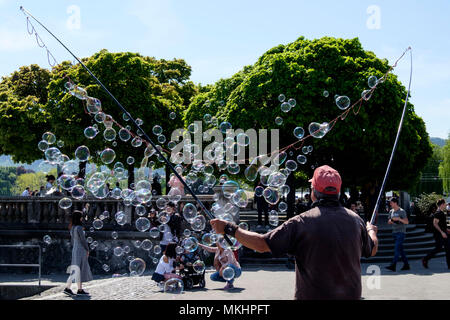 Animatore di strada soffiando grande e colorata bolle di sapone a Zurigo, Svizzera, Europa Foto Stock