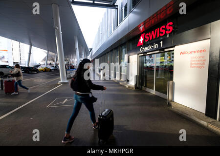 Viaggiatori femmina inserendo l'aeroporto di Zurigo con una valigia scorrevole, Zurigo, Svizzera, Europa Foto Stock
