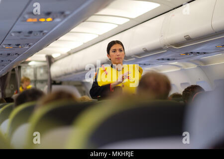 Un assistente di volo dimostrando gonfiabile di giubbotto salvagente usage Foto Stock