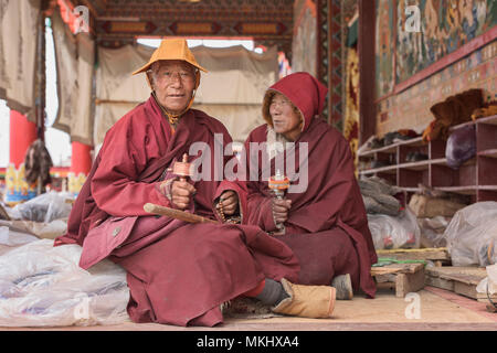 Monaci Tibetani la filatura ruote della preghiera, Yarchen Gar, Sichuan, in Cina Foto Stock