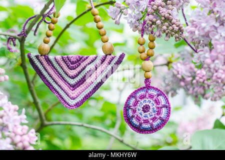 Purple lilac bush un crochet accessori fatti a mano. Fabbricazione artigianale. Ramo di primavera della fioritura lilla. Foto Stock