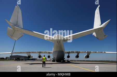 07 maggio 2018, Germania, Lipsia: un uomo camminare sotto un Antonov 225. Il velivolo da carico la misura 84 metri di lunghezza e 89 metri di larghezza e 18 metri di altezza è uno dei tipi. Il velivolo è stato originariamente costruito per il Soviet space shuttle Buran, ed è in grado di trasportare merci di peso fino a 250 tonnellate. Il nolo spazio equivale il tutto il tronco di un Boeing 737. Foto: Jan Woitas/dpa-Zentralbild/dpa Foto Stock