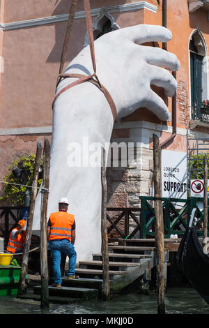 Venezia, Italia. 08 maggio, 2018. Una parte del lavoro di Lorenzo Quinn è smontato e posto su una chiatta di grandi dimensioni per il trasporto a Venezia, Italia il 5 maggio 2018. Il lavoro dell'artista Lorenzo Quinn 'Supporto', noto come 'grandi mani che supportano Venezia', lasciare il Canal Grande per tornare a studio dell'artista in Spagna. © Simone Padovani / risveglio / Alamy Live News Foto Stock