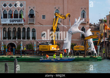 Venezia, Italia. 08 maggio, 2018. Una parte del lavoro di Lorenzo Quinn è smontato e posto su una chiatta di grandi dimensioni per il trasporto a Venezia, Italia il 5 maggio 2018. Il lavoro dell'artista Lorenzo Quinn 'Supporto', noto come 'grandi mani che supportano Venezia', lasciare il Canal Grande per tornare a studio dell'artista in Spagna. © Simone Padovani / risveglio / Alamy Live News Foto Stock