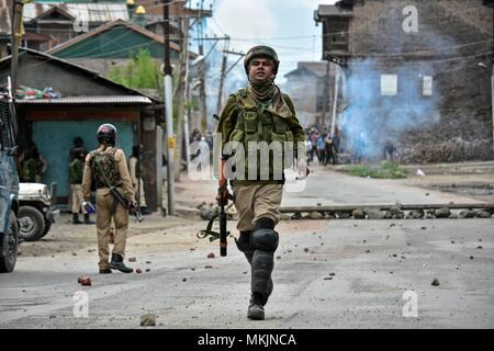 8 maggio 2018 - Srinagar, J&K, India - Un indiano di paramilitari trooper può essere visto in azione durante scontri a Srinagar, Indiano Kashmir amministrato. Violenti scontri scoppiati tra le forze del governo e manifestanti del Kashmir a Srinagar il martedì come la valle ha continuato a rimanere tesa oltre l uccisione di 11 persone di cui 5 militanti e 6 civili in indiano Kashmir amministrato. Polizia strappo utilizzati gusci di fumo e di fucile sparato agglomerati in forma di pellets per disperdere centinaia di manifestanti che hanno lanciato sassi e cantati anti-Indiani e pro-libertà di slogan. Credito: Saqib Majeed SOPA/images/ZUMA filo/Alamy Live News Foto Stock