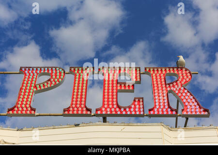 Brighton, East Sussex, 8 maggio 2018. Cerchio Sesagulls iconici illuminato Brighton Pier segno. Un altro meravigliosamente soleggiato e caldo pomeriggio nella cittadina balneare di Brighton in East Sussex potrebbe essere stata l'ultima per un po' di tempo come il tempo meteo per ruotare lo scambiatore di calore e cloudier nei prossimi giorni. Credito: Imageplotter News e sport/Alamy Live News Foto Stock