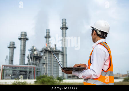 I tecnici stanno lavorando in una turbina a gas impianto di potenza elettrico egli verificare intorno a pianta con notebook Foto Stock