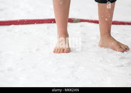 Maschio caucasico in piedi nella neve a piedi nudi Foto Stock