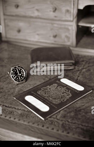 Passaporto britannico, portafogli e orologio rolex sul legname antica scrivania con profondità di campo ridotta, con nome tranciati Foto Stock