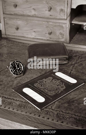 Passaporto britannico, portafogli e orologio rolex sul legname antica scrivania con nome tranciati Foto Stock