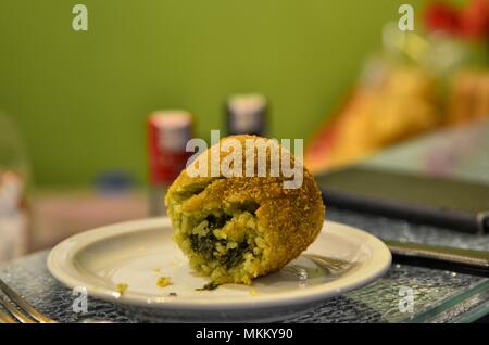 Una specialità della regione Sicilia, Italia: il arancino. Cucina di strada basata sul riso condito in molti modi, ragù di carne, mozzarella, spinaci, piselli. Foto Stock