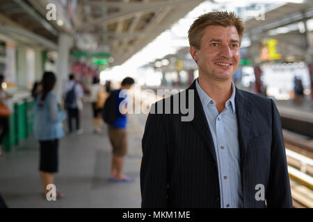 Uomo d'affari presso la stazione del treno sopraelevato a Bangkok, in Thailandia Foto Stock