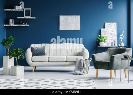 Blue salotto interno con un lettino bianco, grigio poltrona e decorazioni in marmo Foto Stock