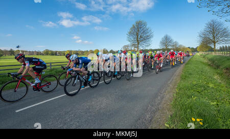 Maschio di ciclisti in peloton, gareggiando in Tour de Yorkshire 2018 & racing su una superficie piana e scenic, campagna lane vicino a Ilkley, North Yorkshire, Inghilterra, Regno Unito. Foto Stock