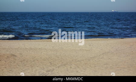 Seascape dalla spiaggia con un lone freighter all'orizzonte Foto Stock