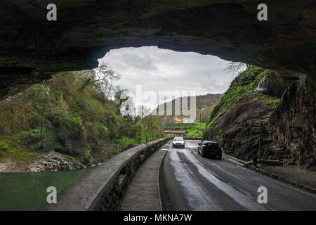 Due vetture e il fiume che scorre attraverso la Porte de l'Arize, ingresso della grotta preistorica Mas-d'Azil, Midi-Pirenei, Pirenei, Francia Foto Stock