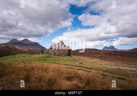 Derelitti agriturismo byre o croft edificio nel paesaggio remoto della North West Highlands della Scozia. Montagne L a R Cul Mor e Suilven Foto Stock